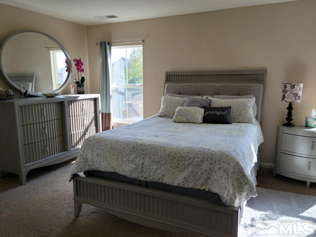 8950 Convair Way Reno, NV 89506 - Photo 9 of 26 a bedroom with a bed a mirror on dresser and a window