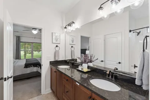 a bathroom with a granite countertop sink a toilet and a mirror