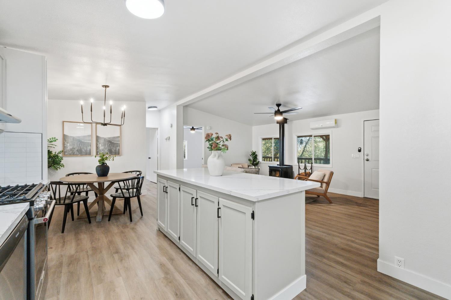 40089 John West Road Oakhurst, CA 93644 - Photo 11 of 59 a kitchen with a dining table chairs wooden floor and appliances