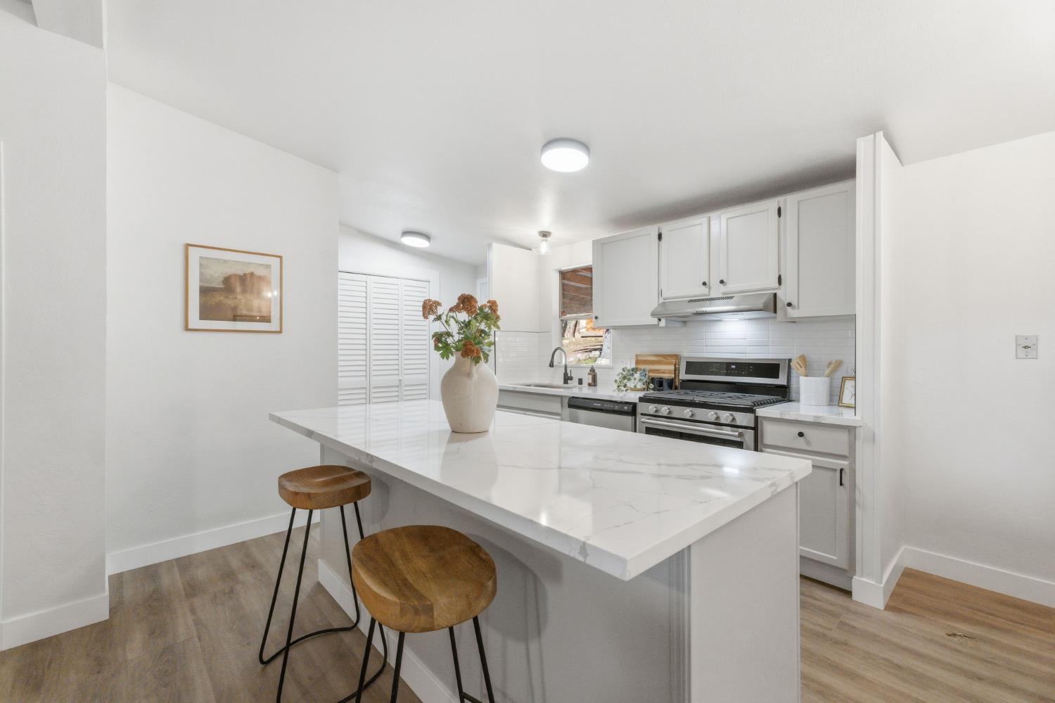 40089 John West Road Oakhurst, CA 93644 - Photo 12 of 59 a kitchen with stainless steel appliances a table and chairs in it