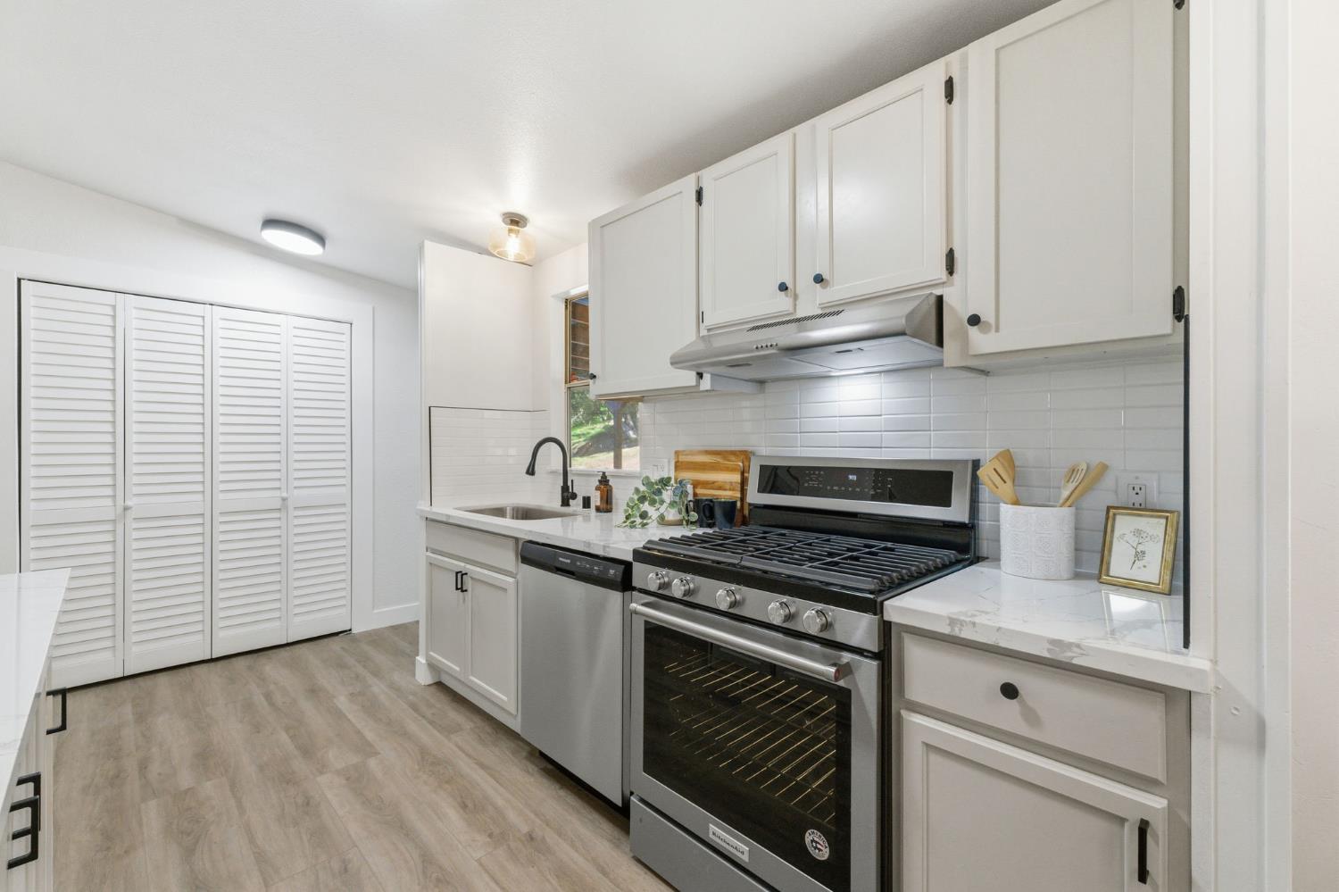 40089 John West Road Oakhurst, CA 93644 - Photo 19 of 59 a kitchen with stainless steel appliances white cabinets and a stove top oven