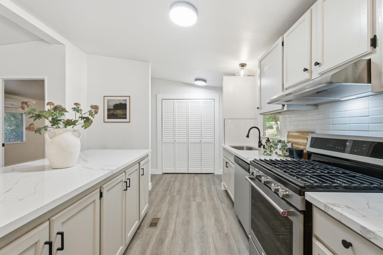 40089 John West Road Oakhurst, CA 93644 - Photo 20 of 59 a kitchen with a sink stove and cabinets