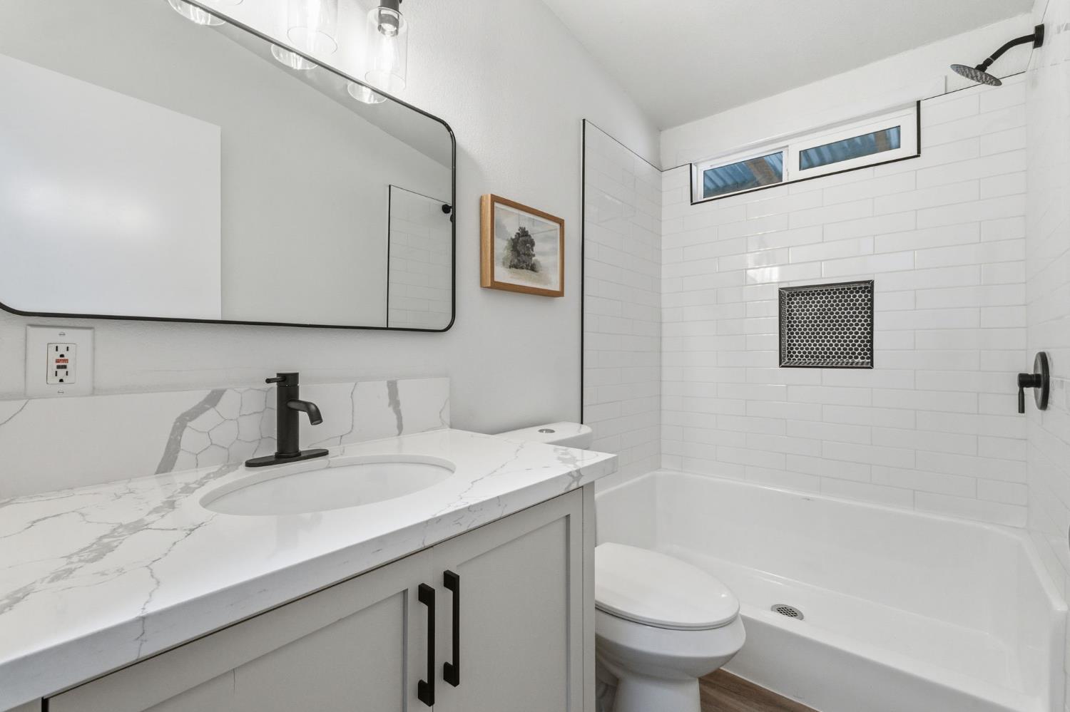 40089 John West Road Oakhurst, CA 93644 - Photo 28 of 59 a bathroom with a granite countertop sink a toilet and a bathtub