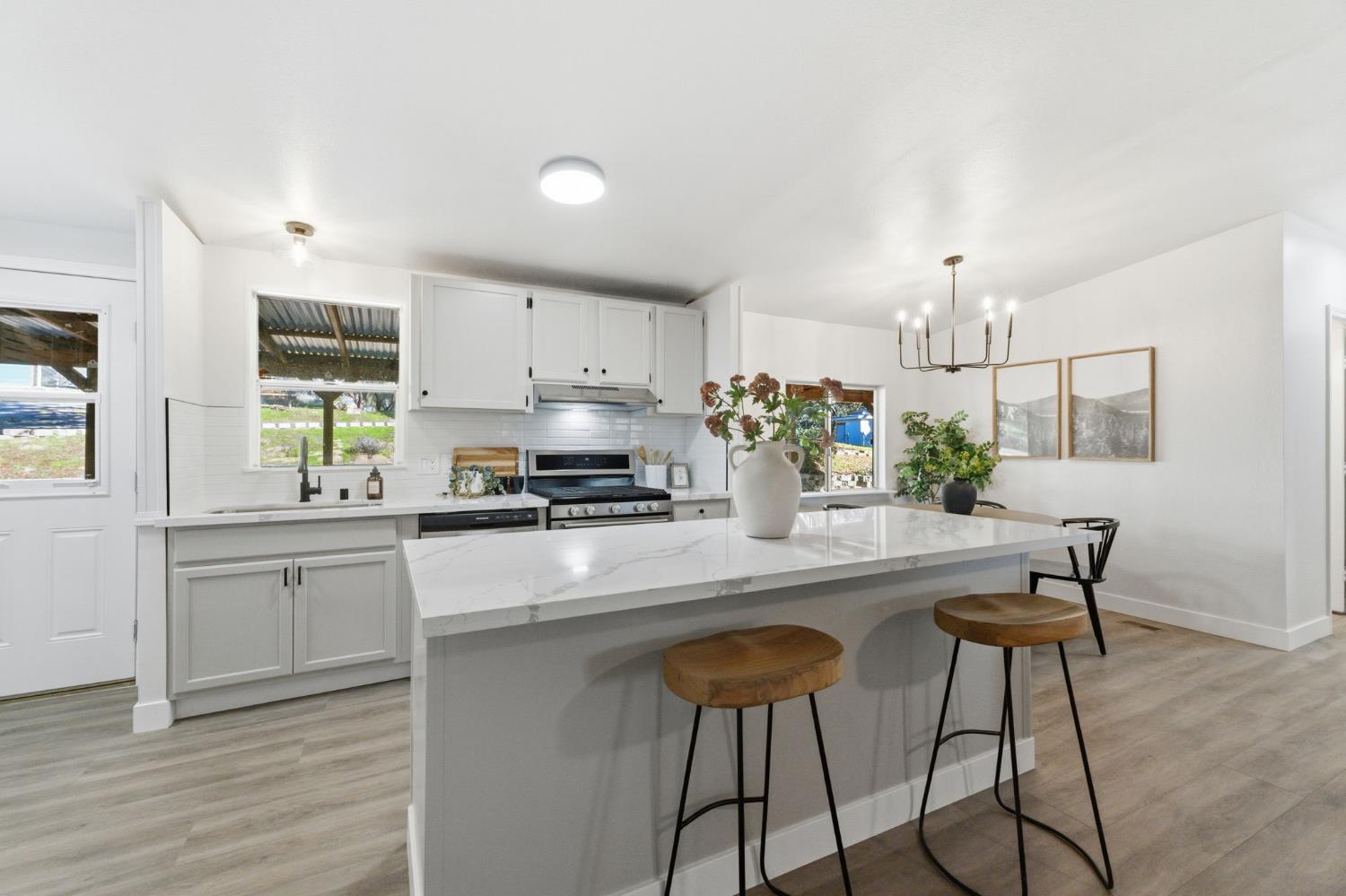 40089 John West Road Oakhurst, CA 93644 - Photo 10 of 59 a kitchen with stainless steel appliances kitchen island granite countertop a stove a sink and a refrigerator
