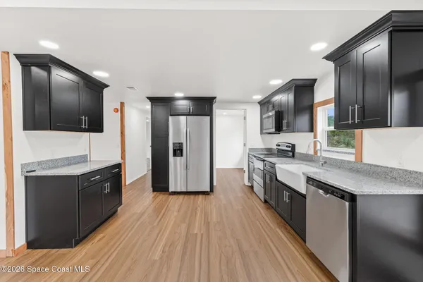 a large kitchen with stainless steel appliances kitchen island granite countertop a large stove top oven and refrigerator