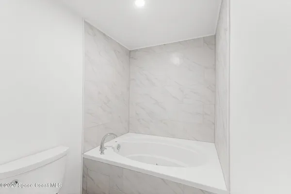 a bathroom with a granite countertop sink a toilet and shower