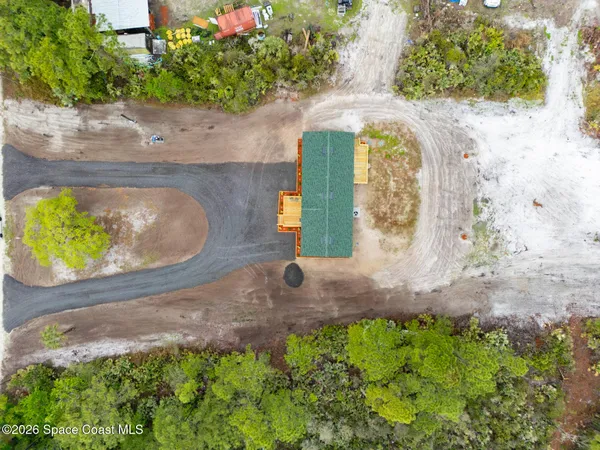 a view of a house with a yard and large trees