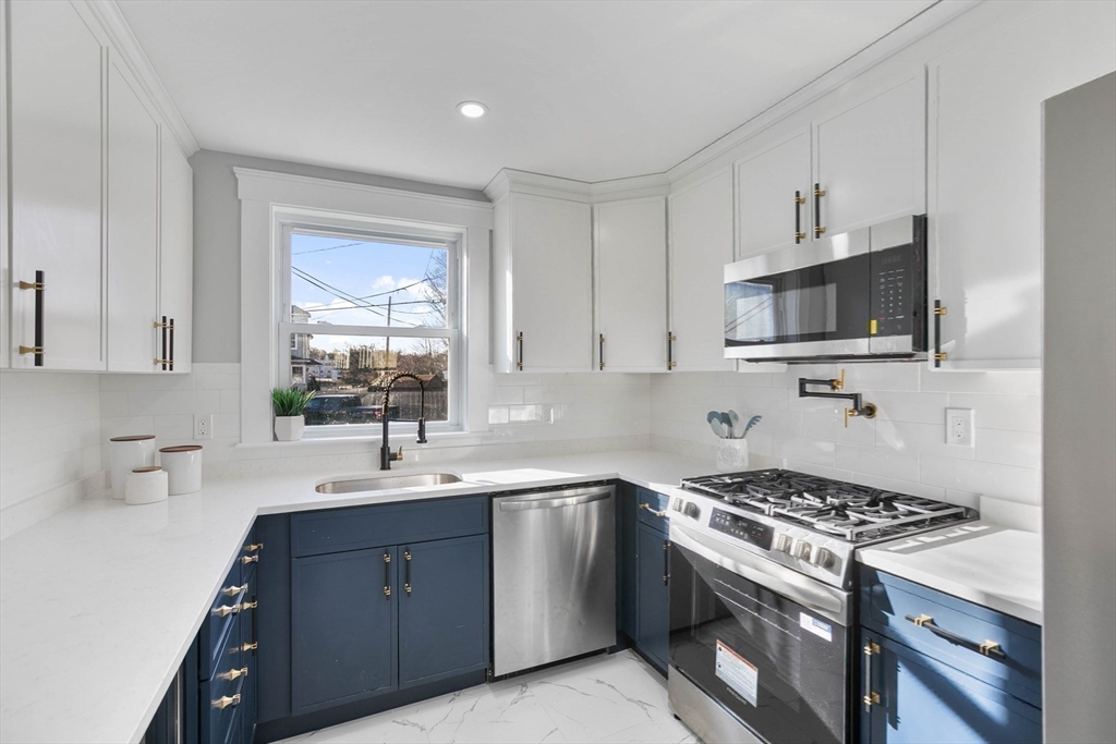 29 Lake View Place Lynn, MA 01904 - Photo 4 of 35 a kitchen with sink a microwave a stove and cabinets