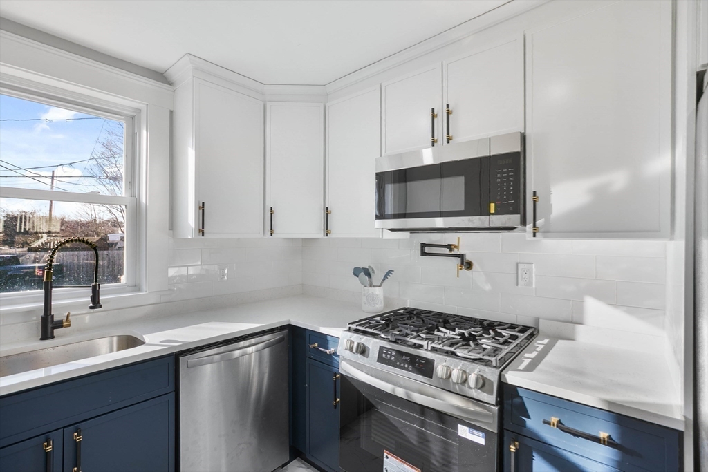 29 Lake View Place Lynn, MA 01904 - Photo 9 of 35 a kitchen with stainless steel appliances a sink a stove and microwave