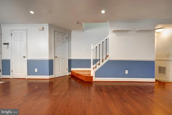 an empty room with wooden floor and fireplace