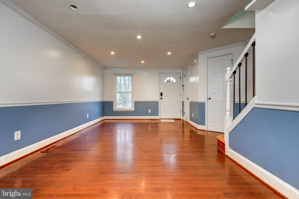 a view of an empty room with wooden floor fire place