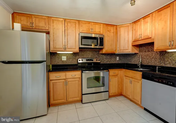 a kitchen with stainless steel appliances a refrigerator sink and cabinets