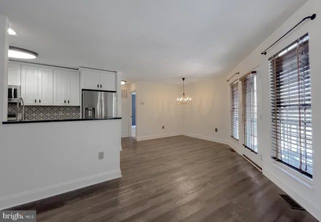 a view of a kitchen with a sink and dishwasher a refrigerator with wooden floor