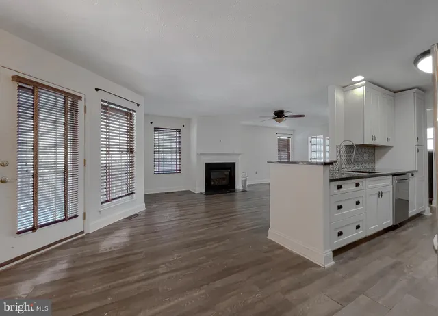 a view of a livingroom with wooden floor and kitchen space