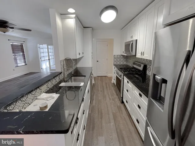 a kitchen with sink stove and refrigerator