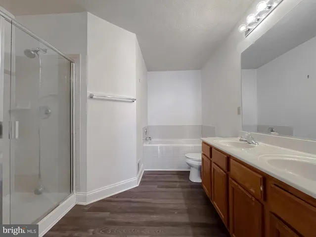 a bathroom with a granite countertop sink a toilet and a bathtub