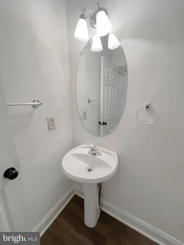 an empty room with a chandelier fan and view of bathroom