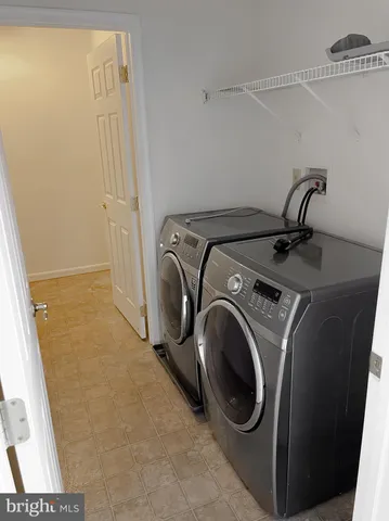 an empty room with a chandelier fan and windows