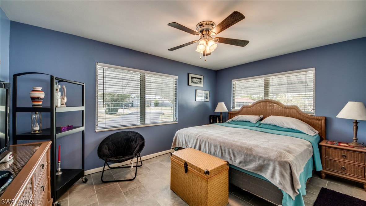 101 Oregon Road West Lehigh Acres, FL 33936 - Photo 18 of 24 a bedroom with a bed and a chandelier