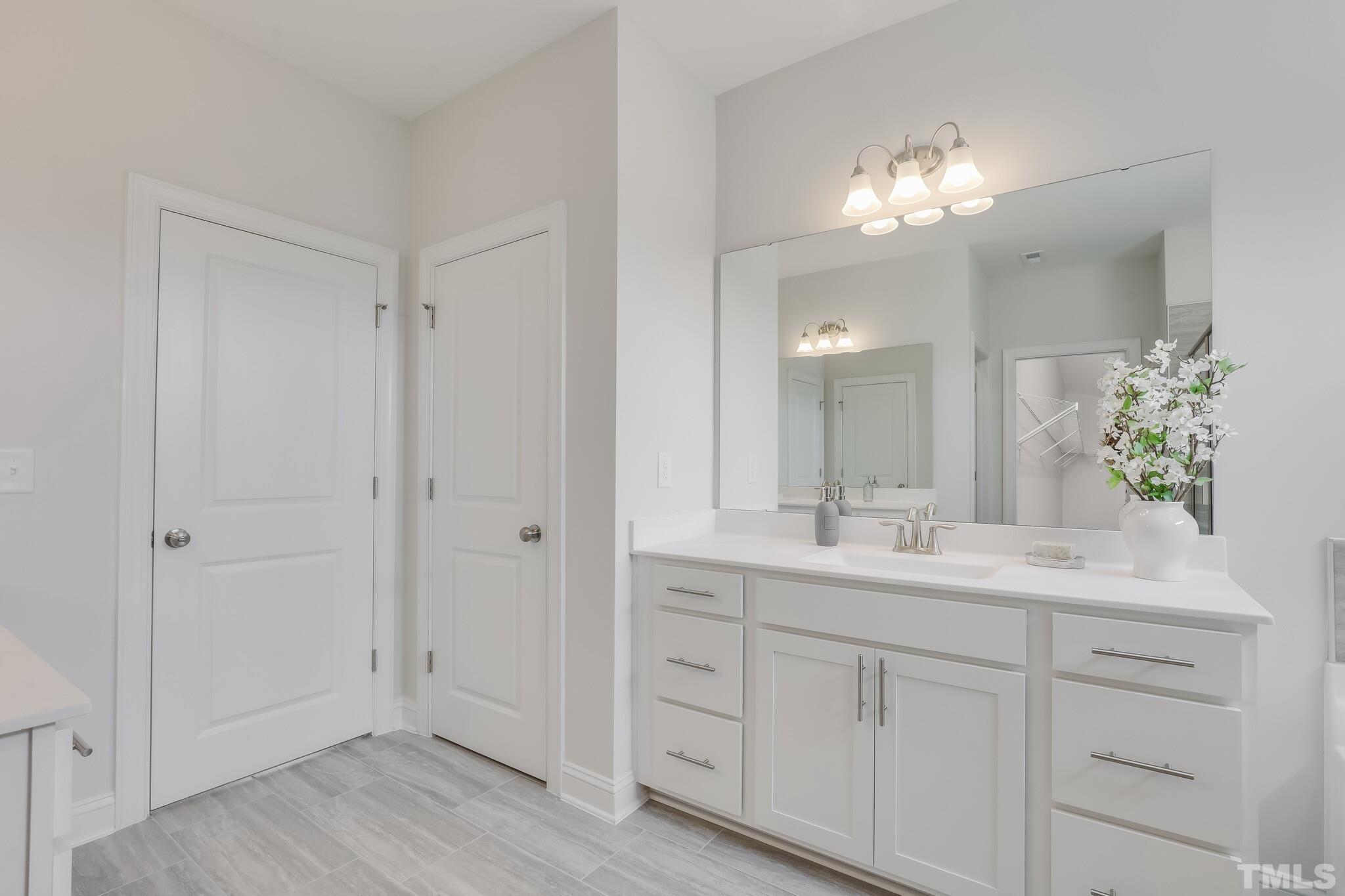 155 Kettleton Circle, Unit 371 Raleigh, NC 27610 - Photo 29 of 38 a bathroom with a double vanity sink and mirror