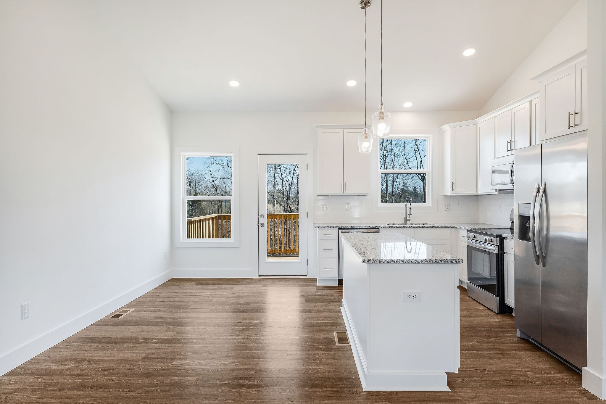 194 Johnson Chapel Road Sparta, TN 38583 - Photo 11 of 35 a kitchen with stainless steel appliances granite countertop a refrigerator a sink dishwasher a stove and white countertops with wooden floor