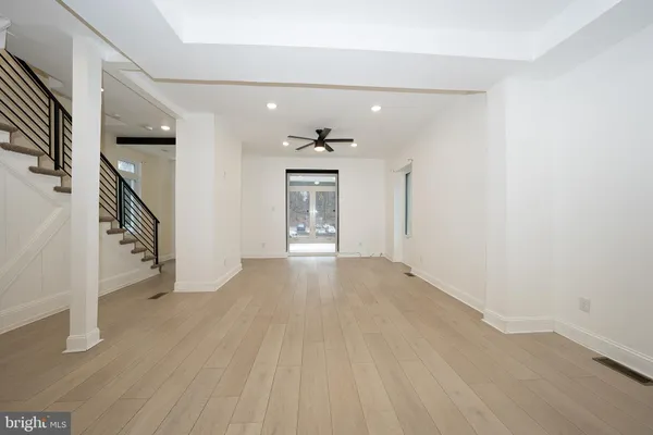 an empty room with wooden floor painted walls and windows