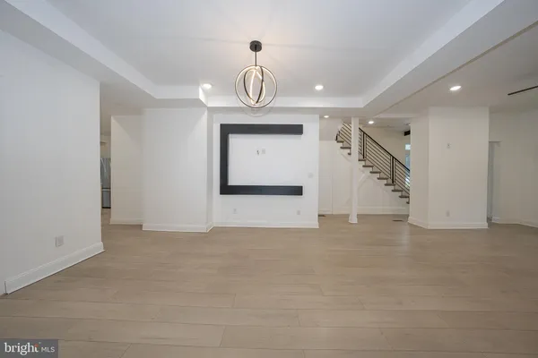 a view of a hallway with wooden floor and a living room
