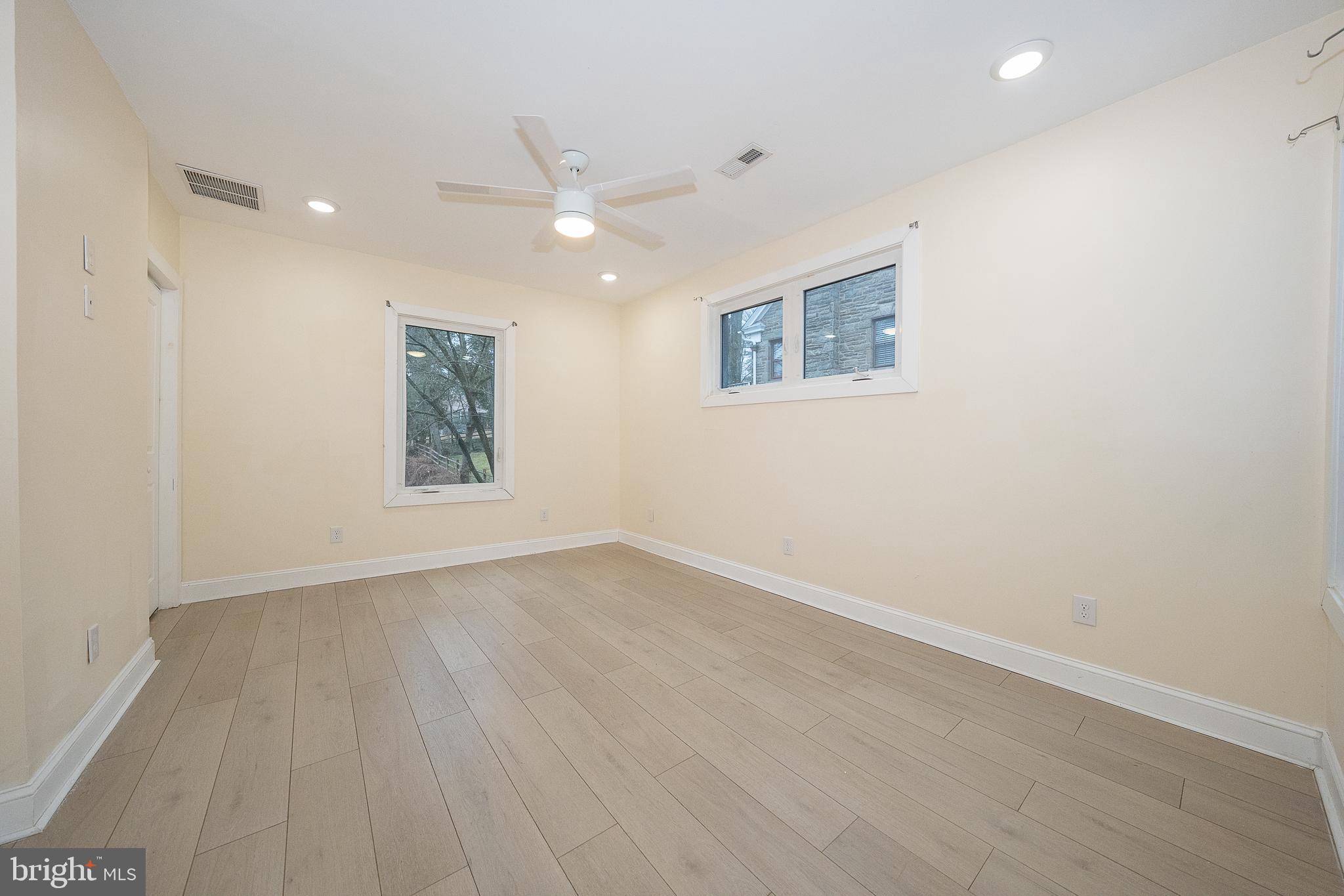 622 Spring Avenue Elkins Park, PA 19027 - Photo 29 of 65 an empty room with wooden floor a ceiling fan and windows