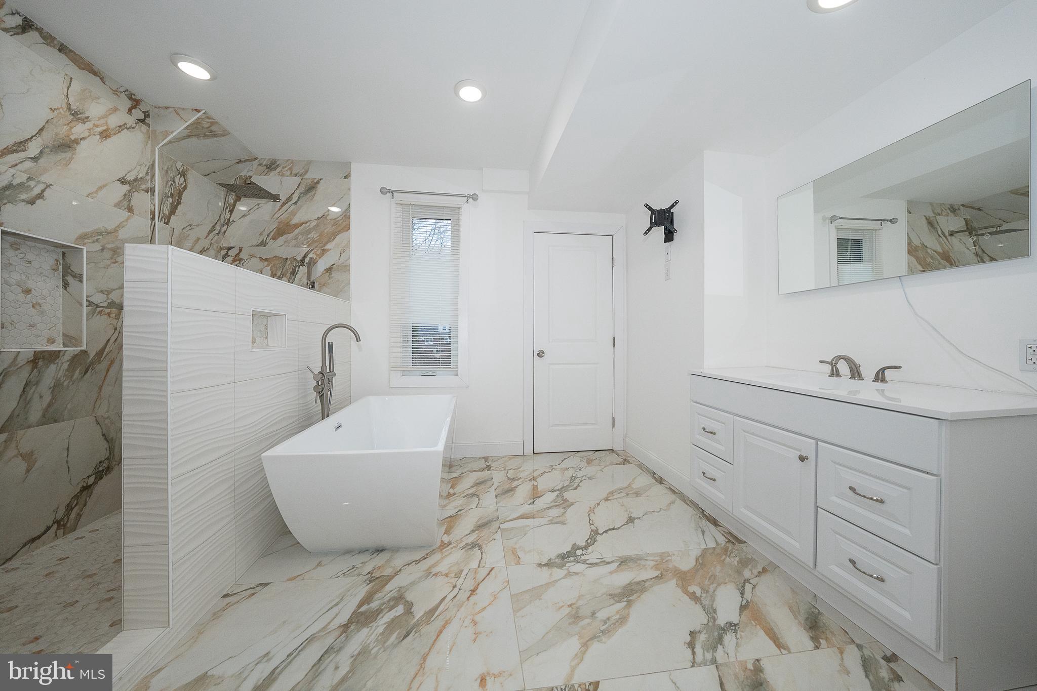 622 Spring Avenue Elkins Park, PA 19027 - Photo 36 of 65 a spacious bathroom with a tub sink and mirror