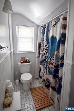 a bathroom with a toilet and a shower curtain
