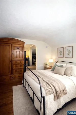 a spacious bedroom with a bed and lamp