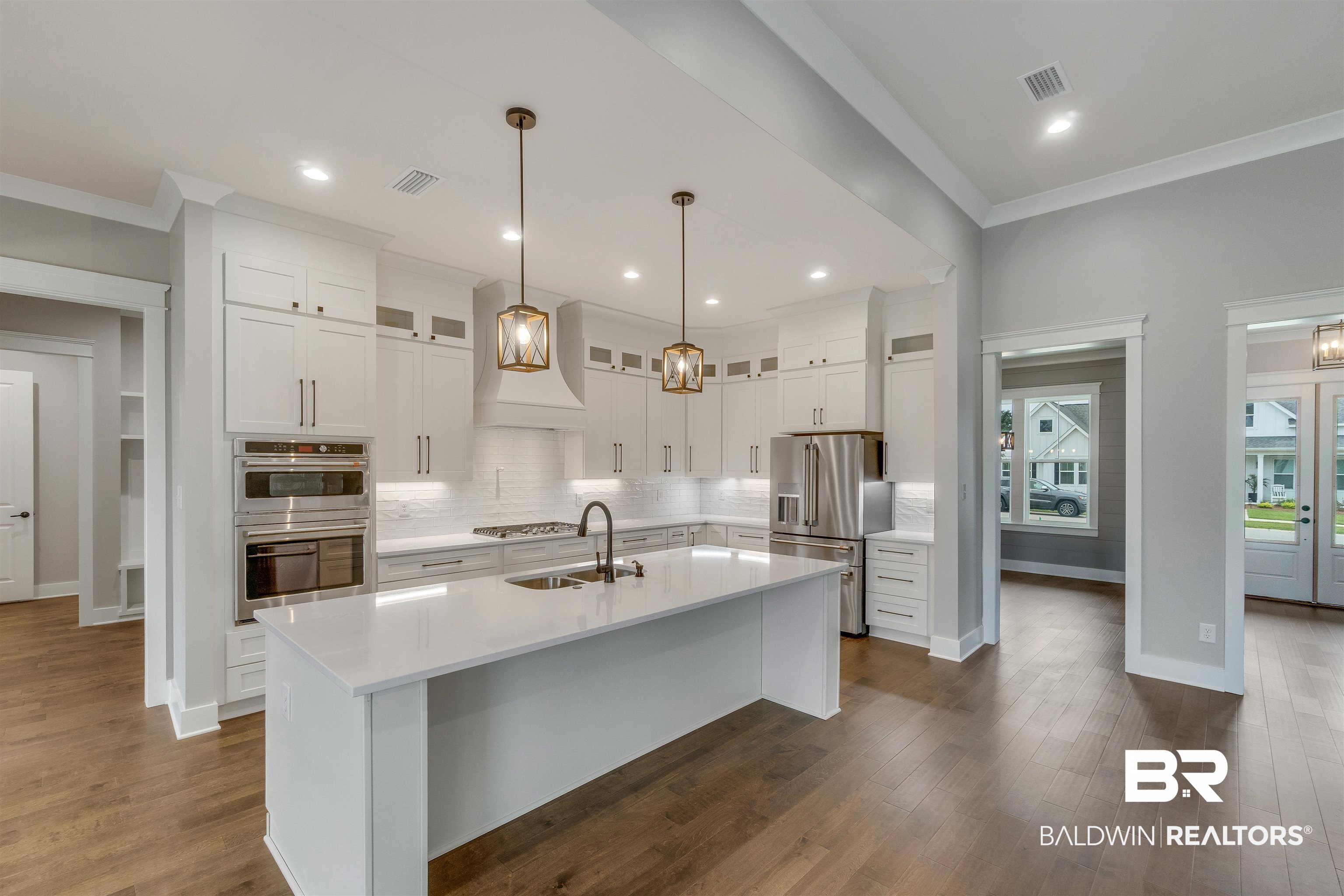 10985 Atrium Avenue Fairhope, AL 36532 - Photo 12 of 58 Kitchen featuring tasteful backsplash, decorative light fixtures, white cabinets, appliances with stainless steel finishes, and glass insert cabinets