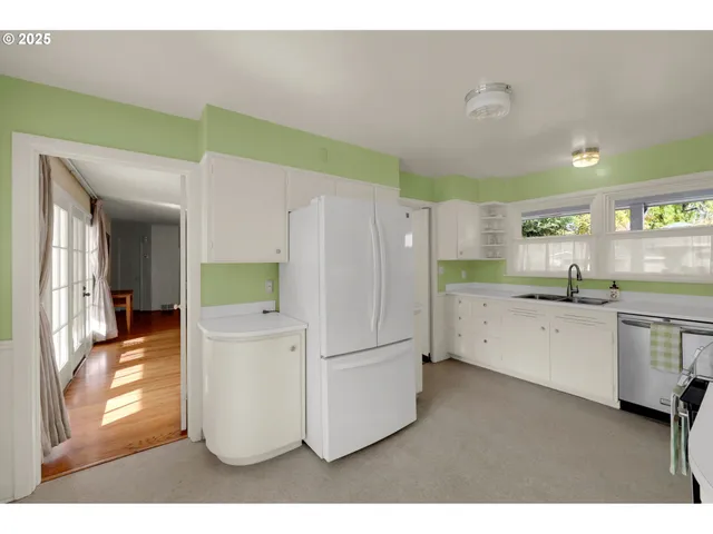 a kitchen with refrigerator and cabinets