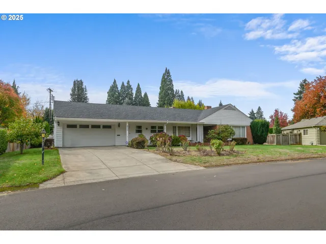 a view of a house with a yard and potted plants