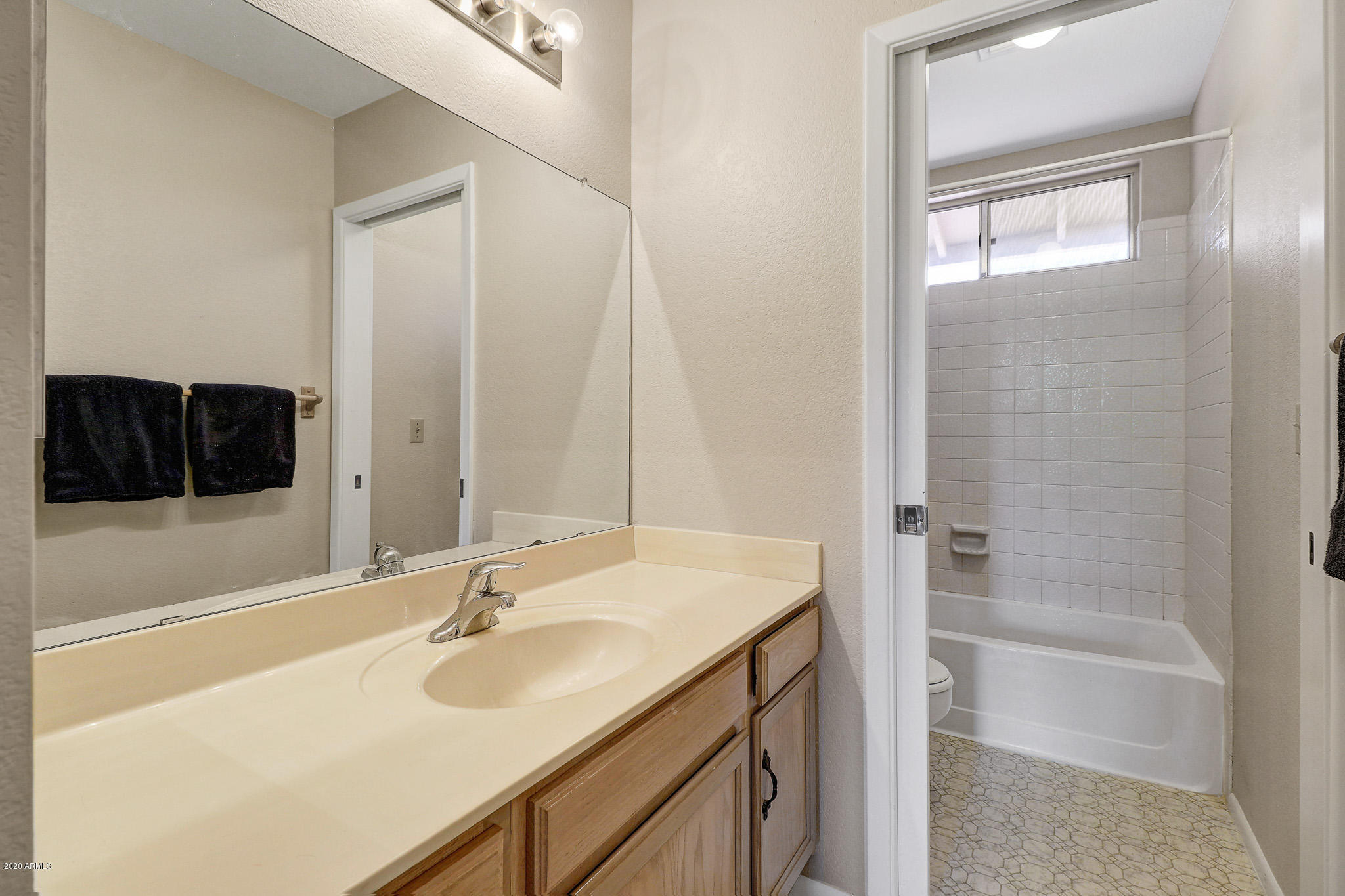 1902 East Redfield Road Phoenix, AZ 85022 - Photo 16 of 31 a bathroom with a granite countertop sink a mirror and a bathtub