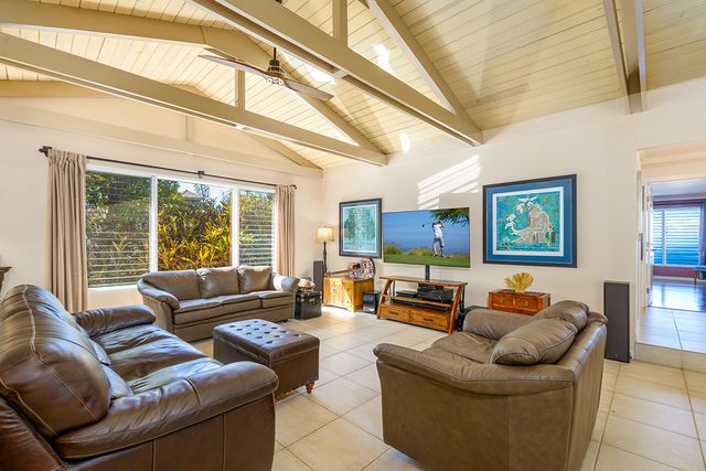 a living room with furniture and view of kitchen