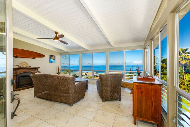a living room with furniture a large window and kitchen view