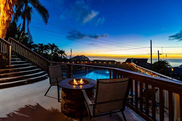 a view of a balcony with chairs and a potted plant