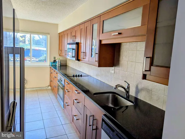 a kitchen with stainless steel appliances granite countertop a sink and a stove