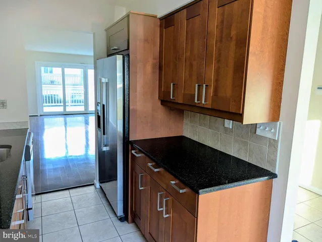 a kitchen with granite countertop a refrigerator and a sink