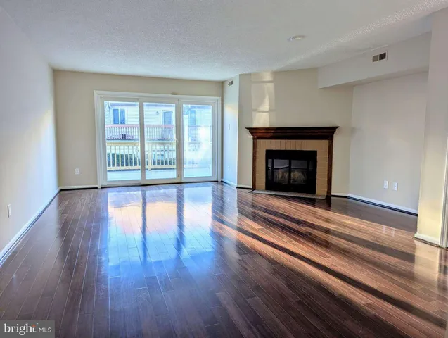 wooden floor fireplace and windows in an empty room