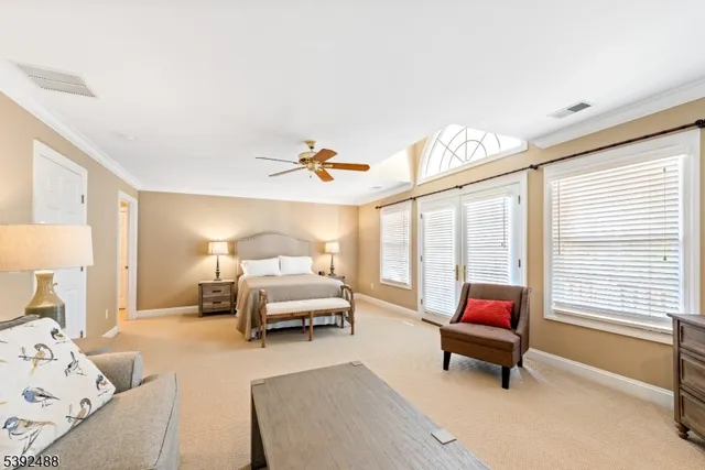 a spacious bedroom with a bed and a chandelier
