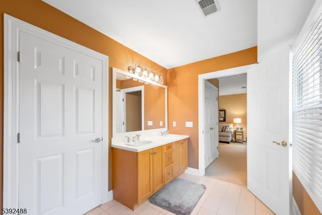a spacious bathroom with a double vanity sink a mirror and a bathtub