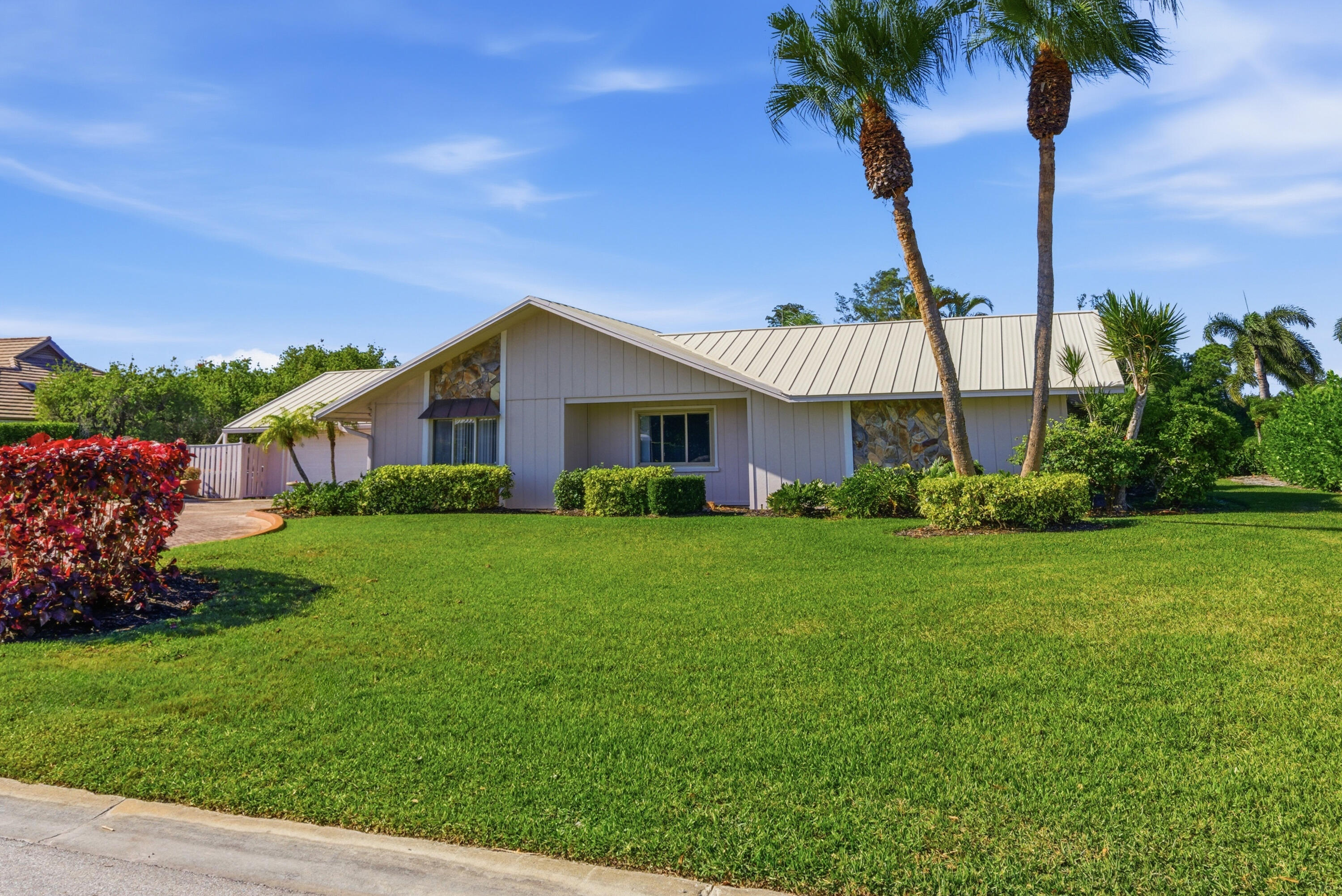 5151 Southeast Burning Tree Circle Stuart, FL 34997 - Photo 3 of 74 a view of a house with a yard and a palm tree