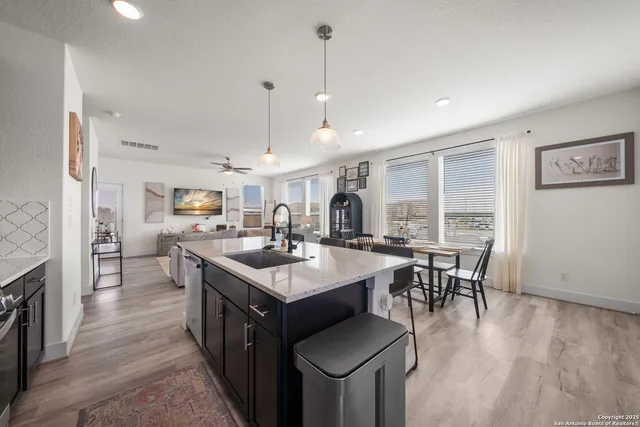 a kitchen with granite countertop a sink a counter space appliances and cabinets