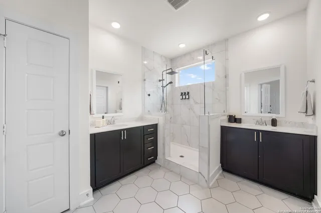 a bathroom with a double vanity sink mirror and shower