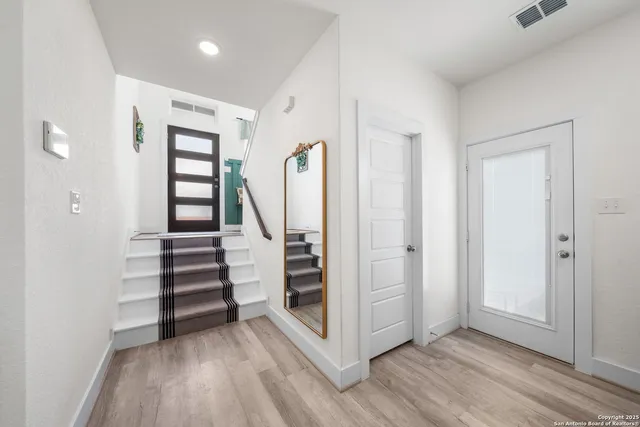 an empty room with wooden floor closet and windows