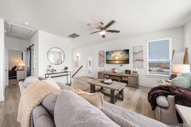 a kitchen with stainless steel appliances a microwave a stove a refrigerator and a dining table with wooden floor