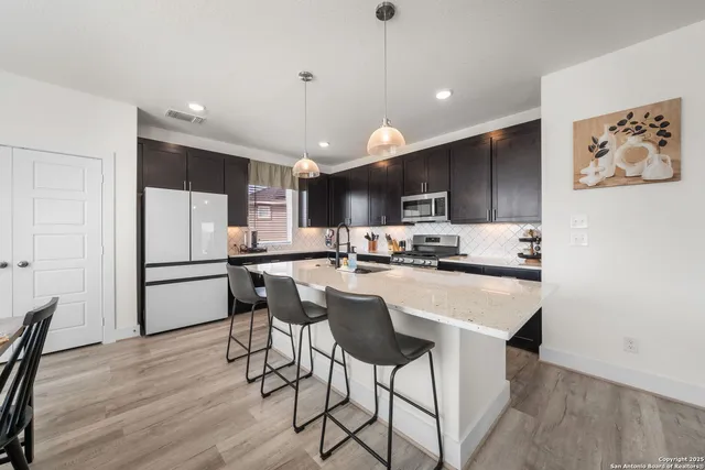 a large kitchen with kitchen island a sink table and chairs