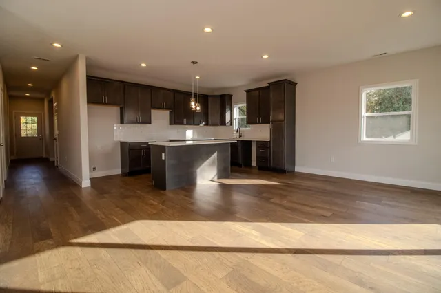 a view of kitchen with stainless steel appliances granite countertop refrigerator sink and stove